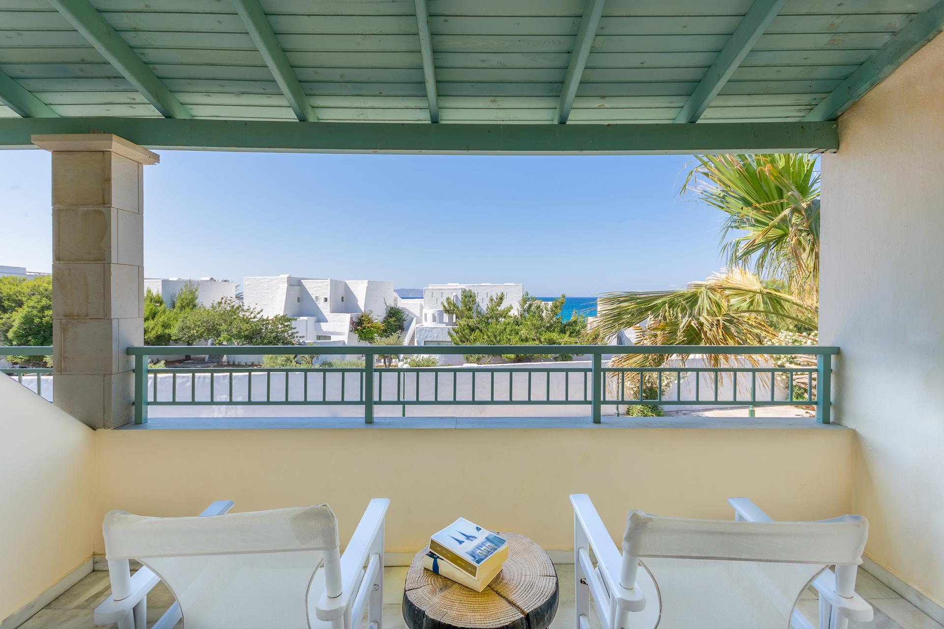 Knossos Beach Signature Room balcony with a small round table, two chairs and view